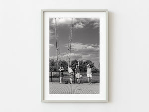 Friends watching their children as they pass by on an amusement park ride | Photo Art Print fine art photographic print