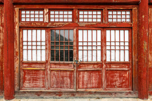Vibrant red door embedded in gray stone wall